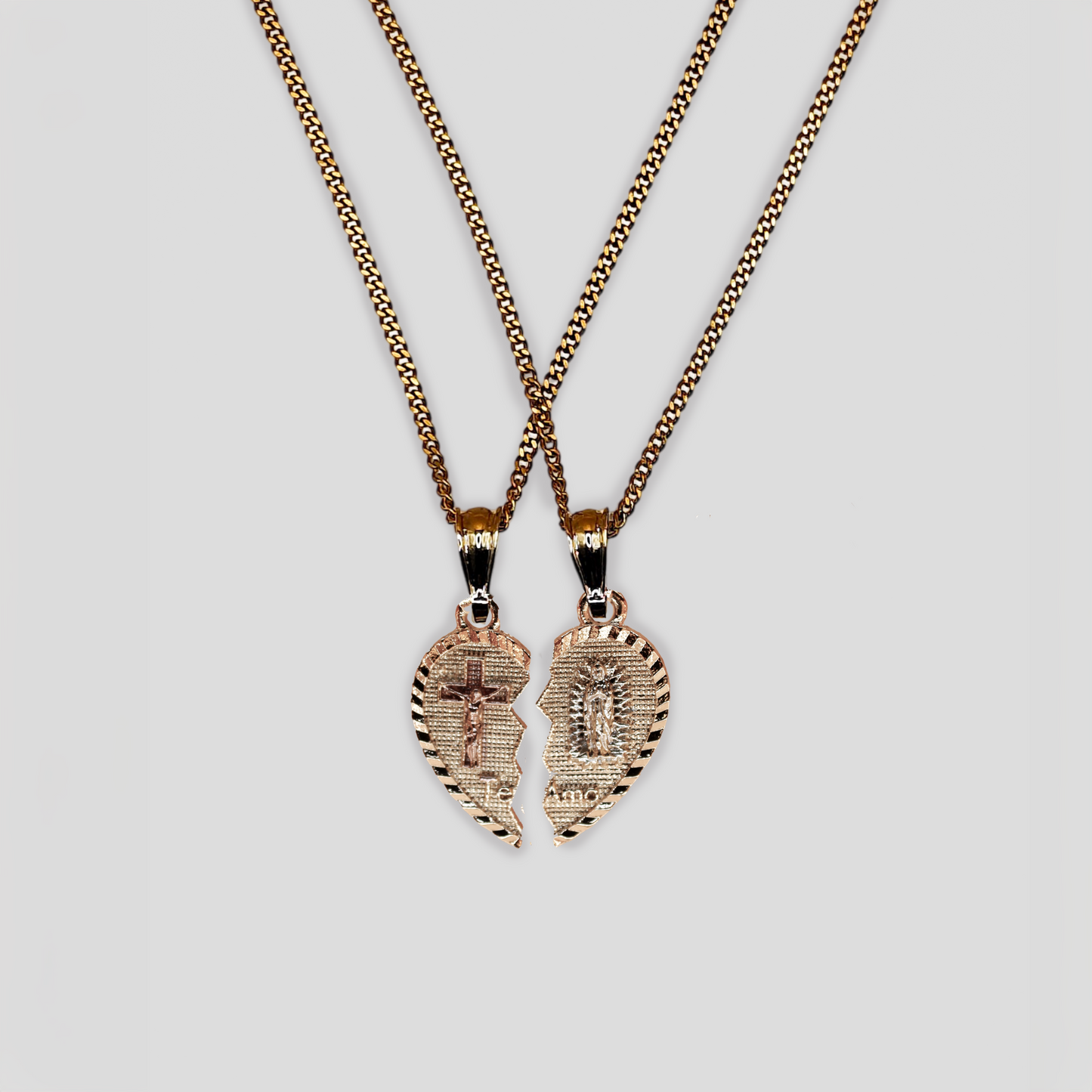 A gold color heart-shaped pendant that is split into two halves. On one half, there's a raised, textured cross, and on the other, an etched image of the Virgin Mary. Between them, the phrase "Te Amo" is engraved, which translates to "I Love You" in Spanish.