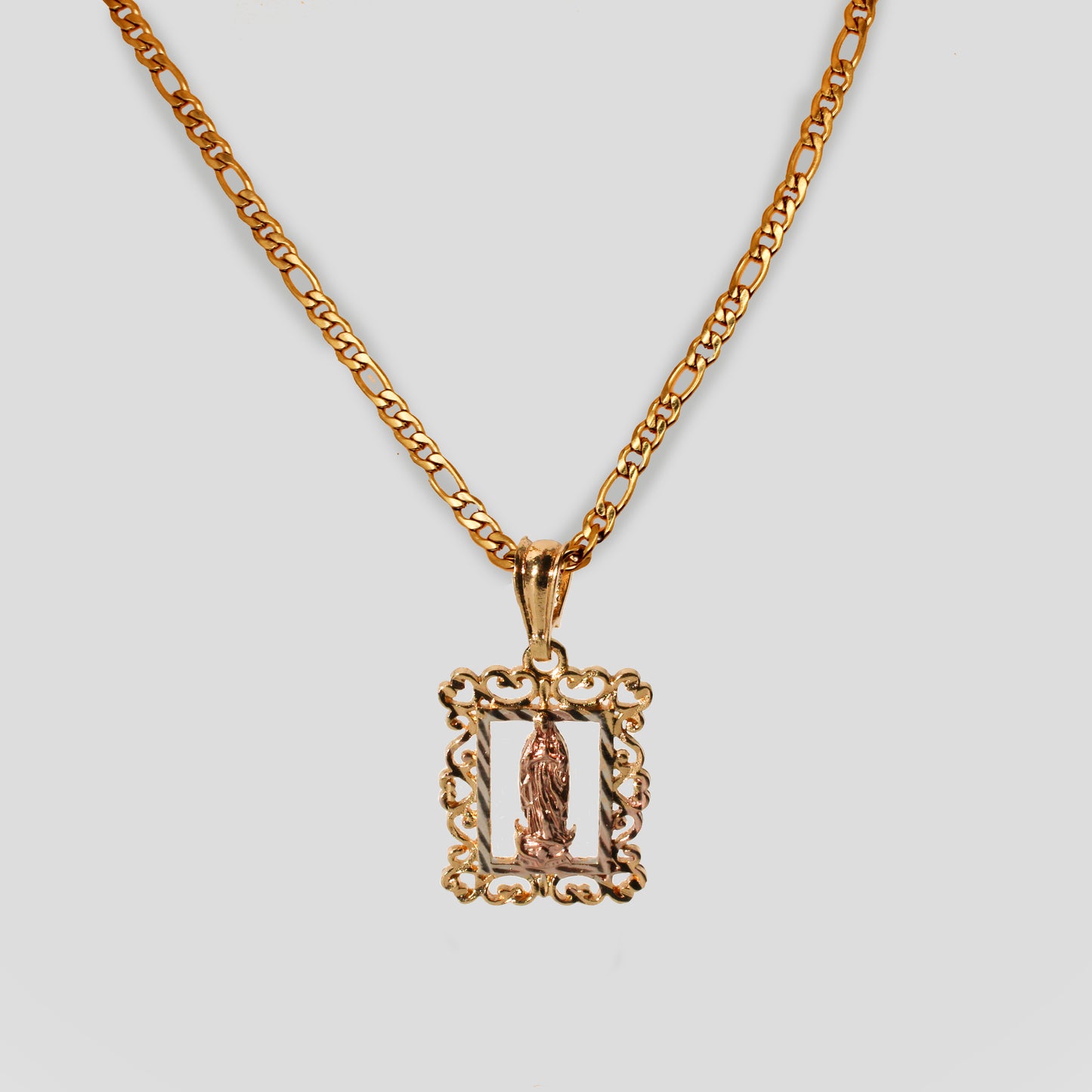A necklace with a figaro chain and a pendant featuring a rectangle frame shape centered with the Virgin Mary.