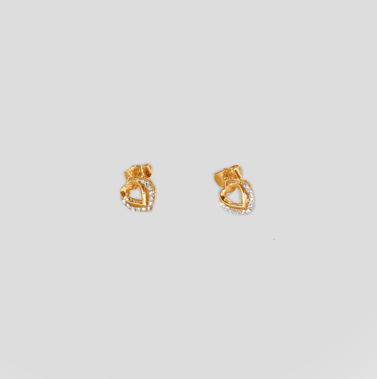 Gold-colored heart-shaped stud earrings adorned with simulant diamonds.