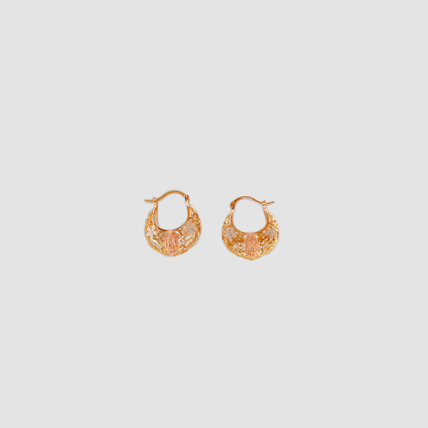 A pair of gold color earrings with the Virgin Mary with flowers on each side.