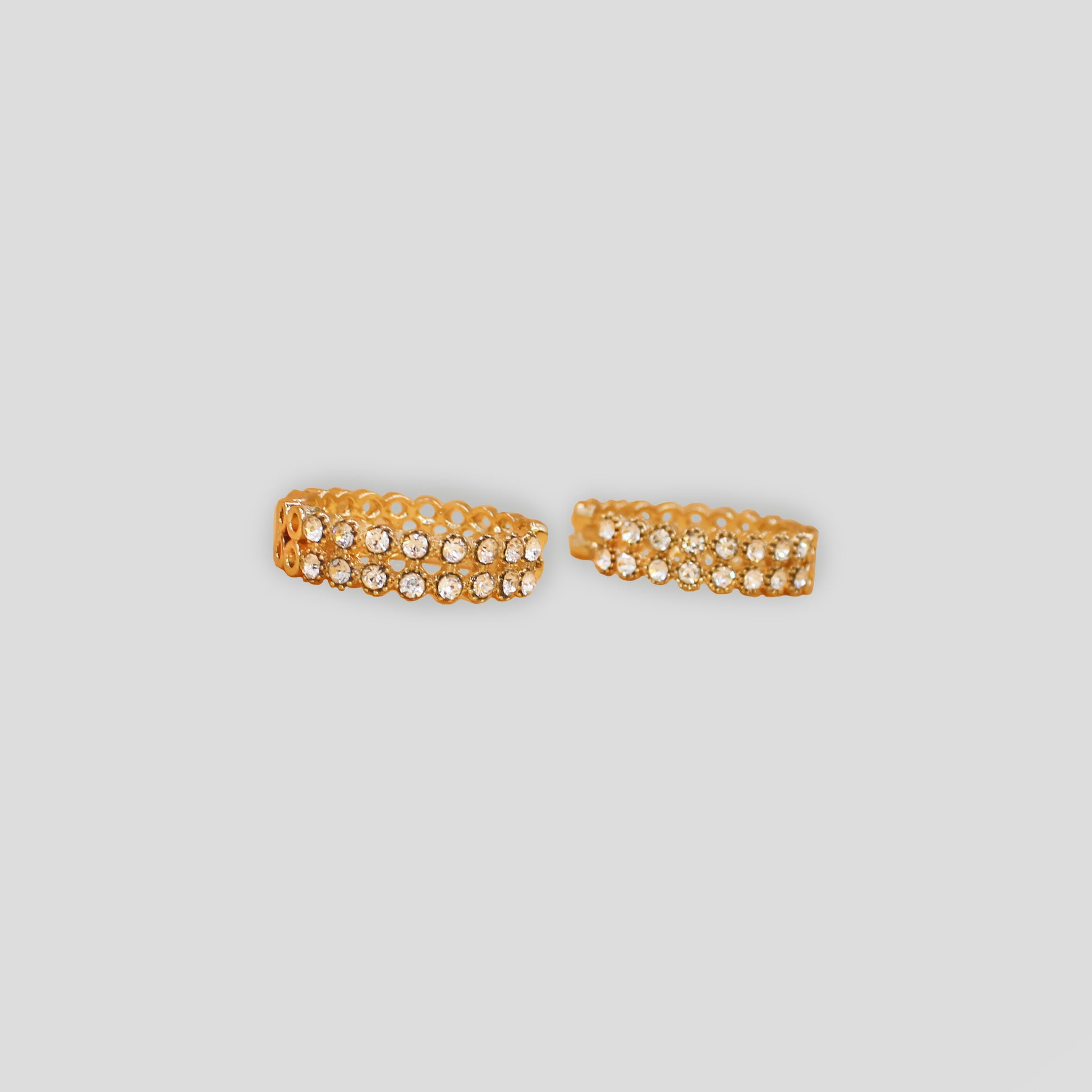 Horizontal gold-colored hoop earrings with double rows of sparkling simulant diamonds.