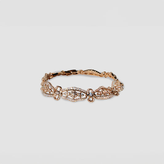 Gold-colored bracelet with intricate floral and oval-shaped designs, adorned with simulant diamonds.