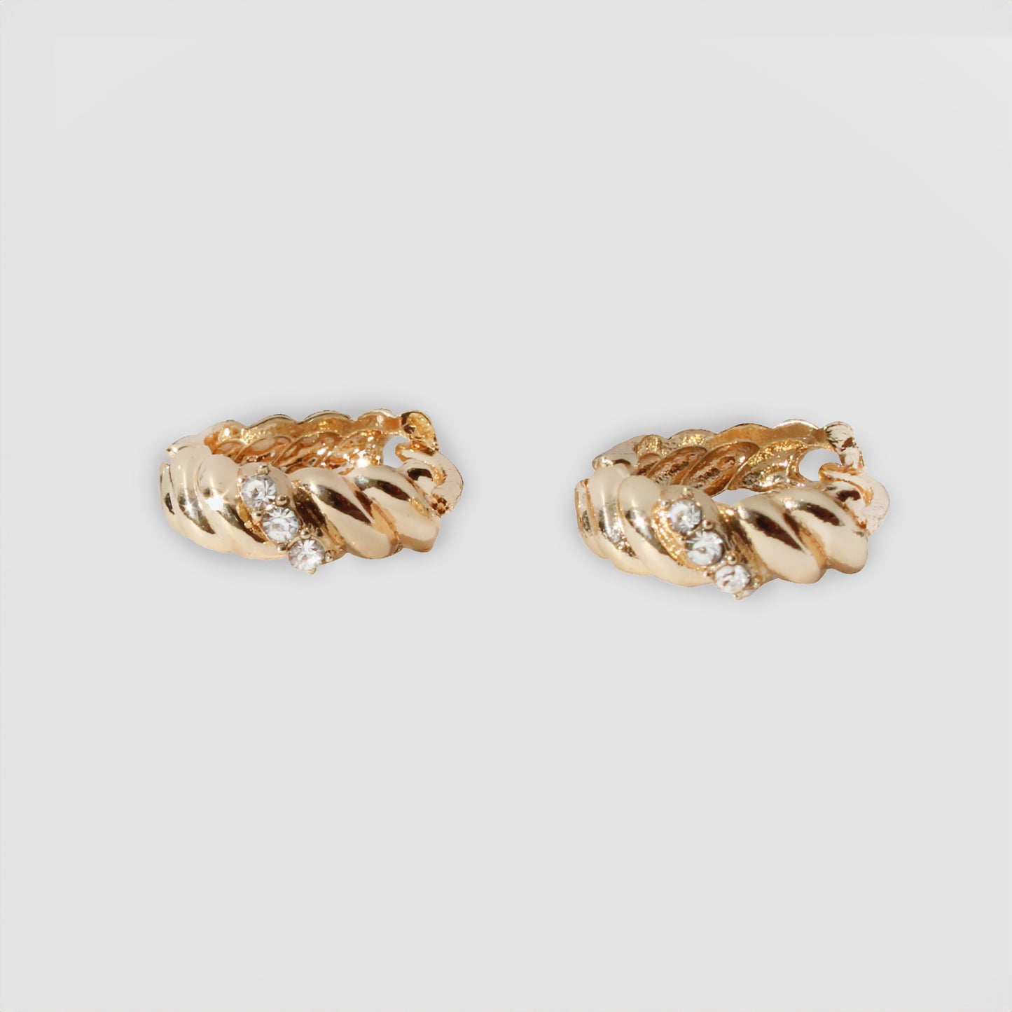 Gold-colored twisted hoop earrings adorned with small simulant diamonds.