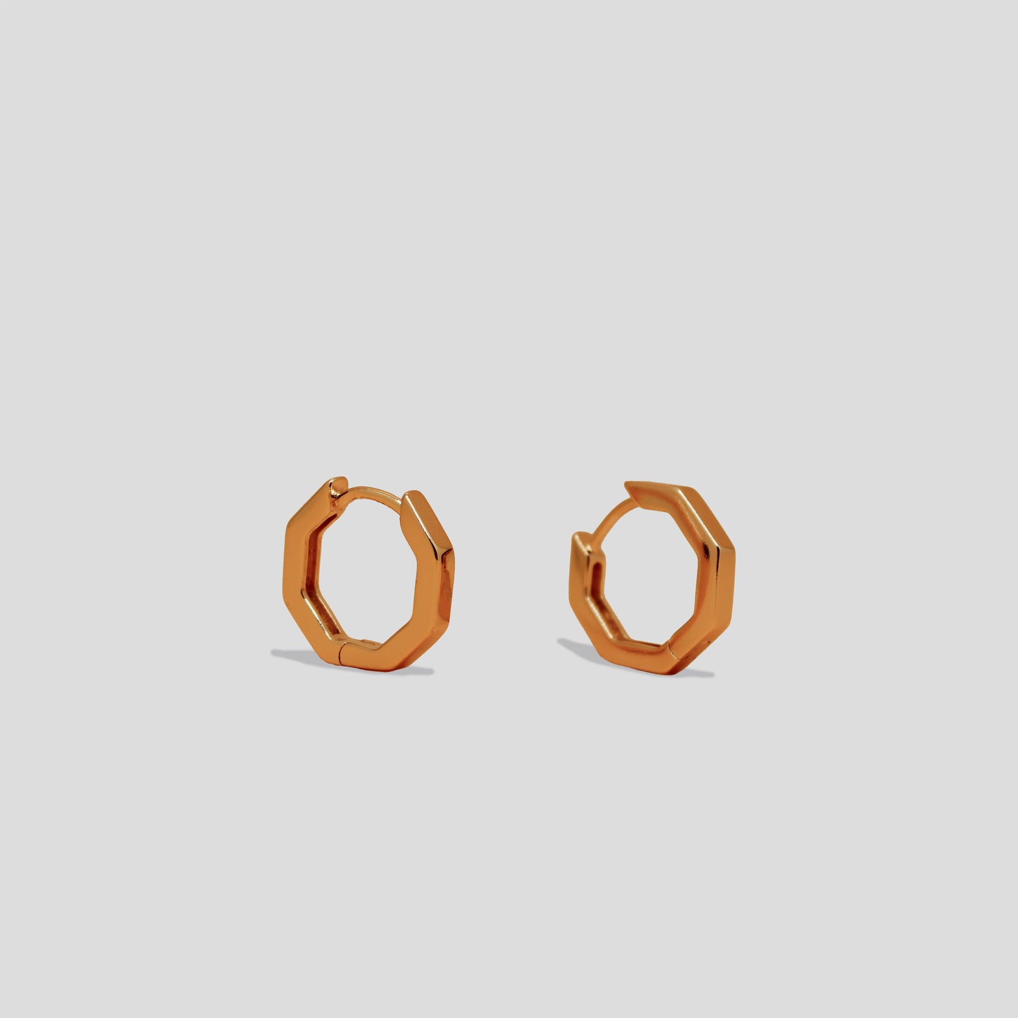 Gold-colored hexagonal hoop earrings with a sleek, modern design.