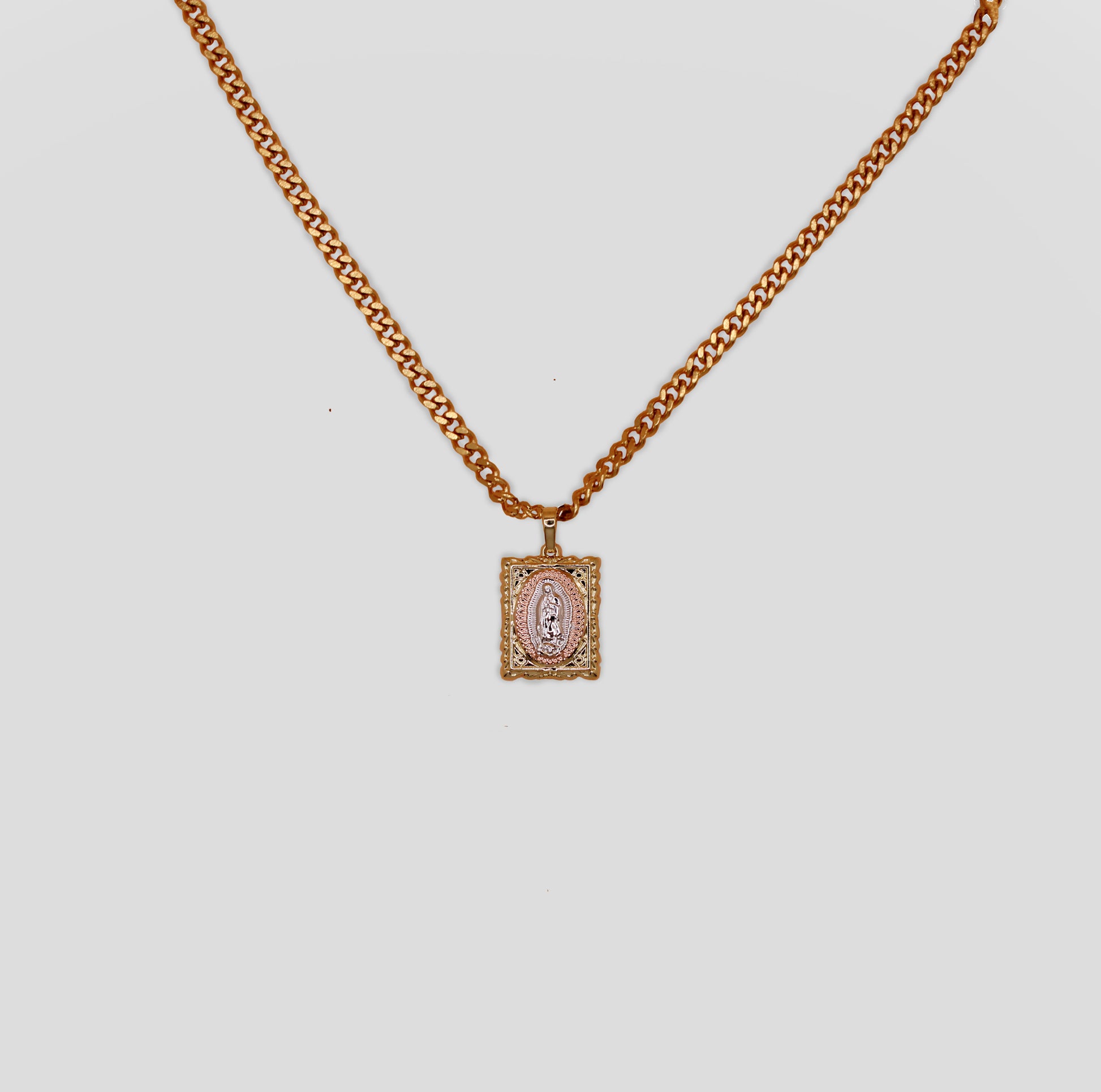 A Virgin Mary gold color pendant necklace with a textured chain.