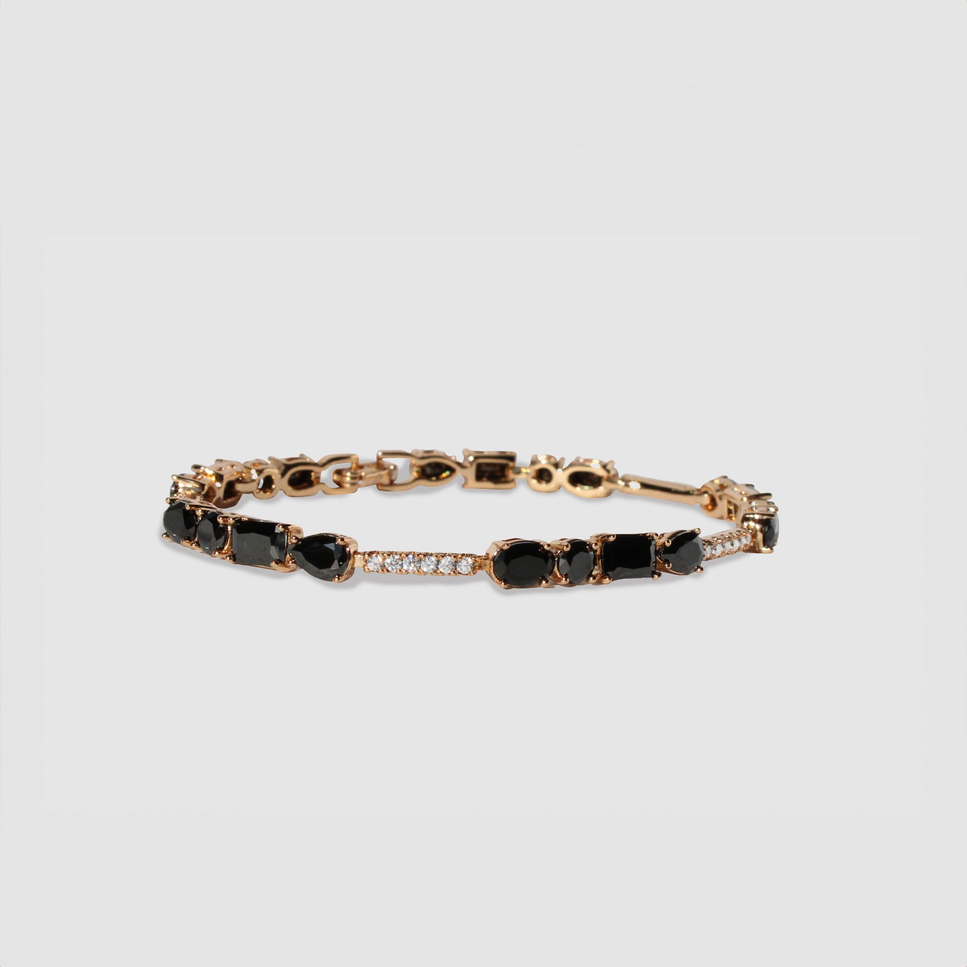 Gold-colored bracelet with black gemstones and simulant diamonds