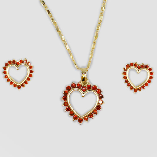 Gold-colored heart-shaped necklace and earrings set, featuring red gemstones around the open-heart design.