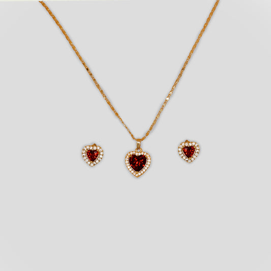 A matching set that includes a necklace with earrings of a red gemstone heart surrounded by white rhinestones. The earrings have the same design as the pendant of a red heart.