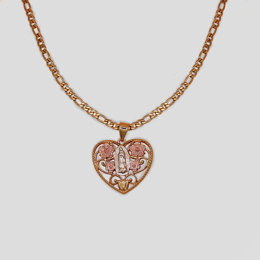 A necklace with a figaro chain and heart pendant featuring the Virgin Mary and pink flowers behind the Virgin Mary.