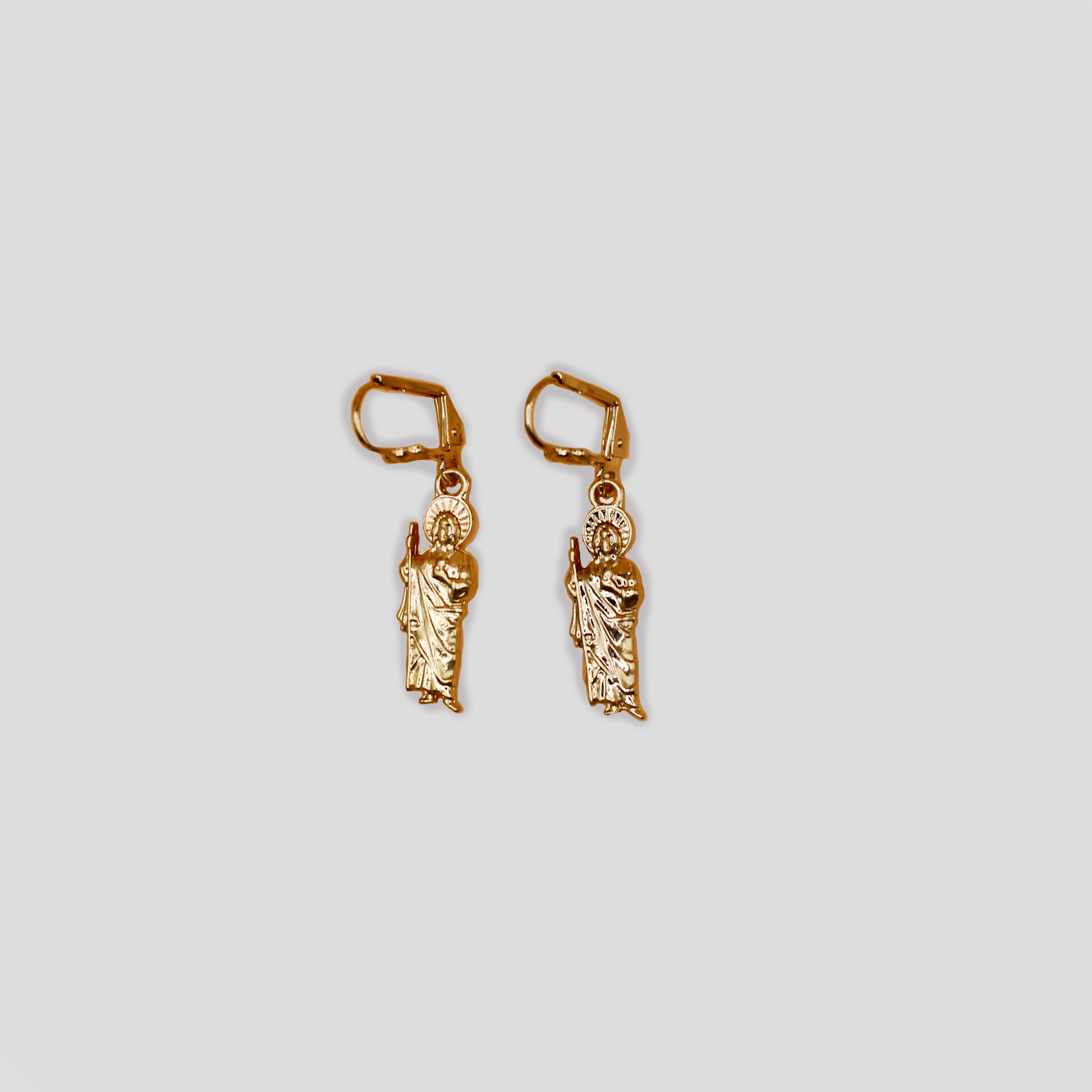 A pair of earrings featuring San Judas.