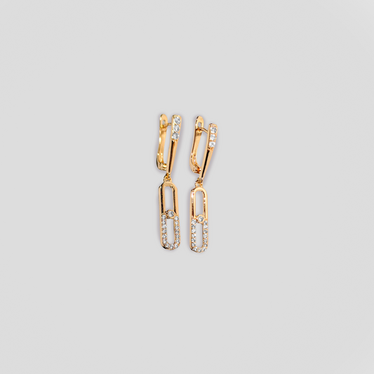 A pair of gold color earrings with diamonds.